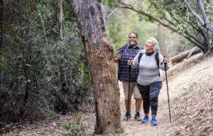 A couple hiking a trail in a forest.