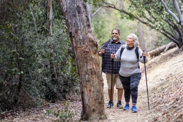 A couple hiking a trail in a forest.