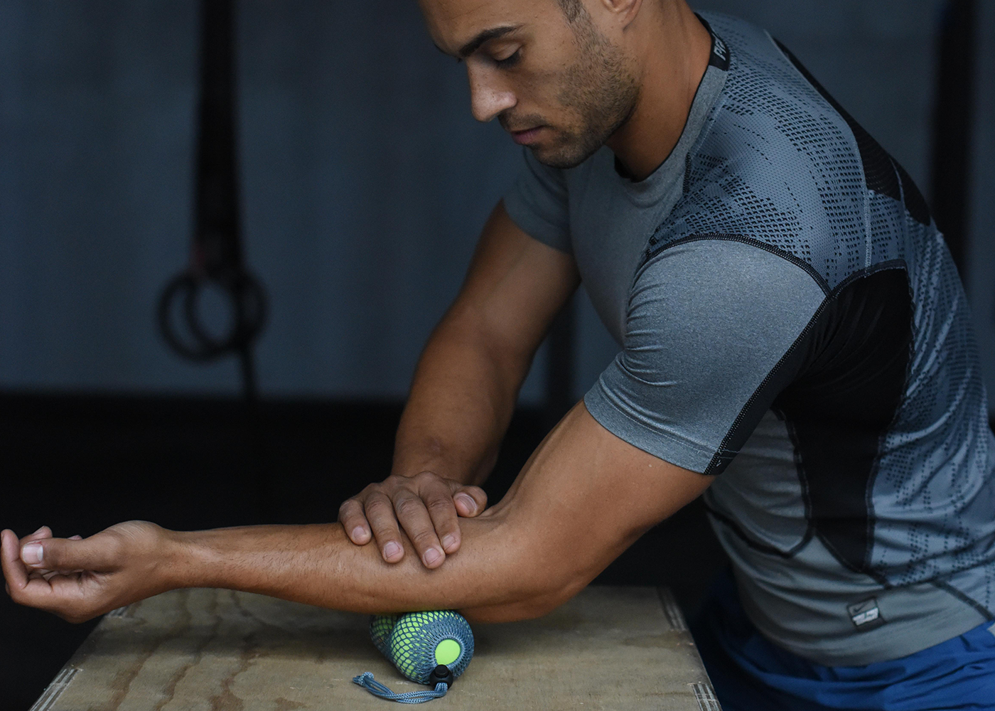 Man rolling out the muscles on the top of the arm with Yoga Tune Up Therapy Balls