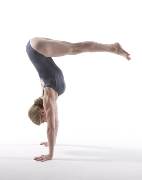 The woman lifts her body with her hands while keeping her legs straight in the air.