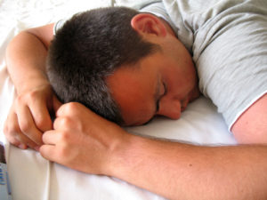 The man sleeps soundly, fully relaxed and at peace.