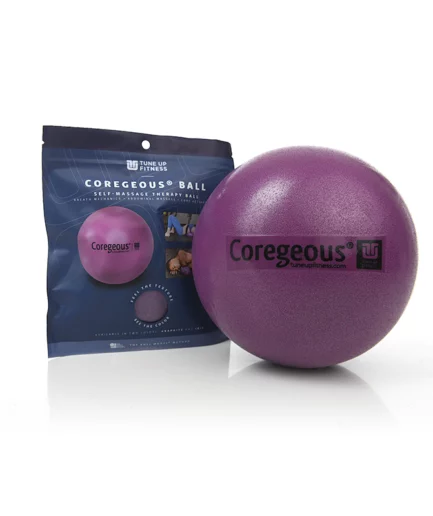 The purple Yoga Tune Up Coregeous Ball with black text, displayed in front of its dark, branded retail packaging