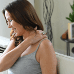 A woman feels pain in her back and shoulders.