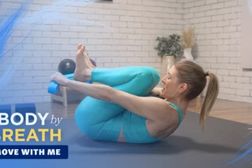 A woman performing a seated yoga or pilates exercise.
