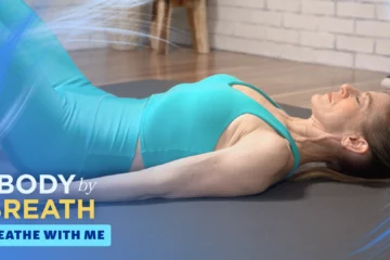 A woman in teal athletic wear lies on a gray yoga mat, her head resting back.