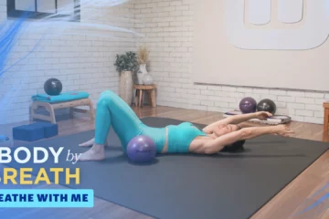 a woman performing a pilates exercise, using the therapy balls