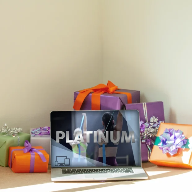 Platinum Subscription Section Image Tune Up Fitness Platinum subscription displayed on a laptop surrounded by wrapped gifts, highlighting premium on-demand fitness and self-care content.